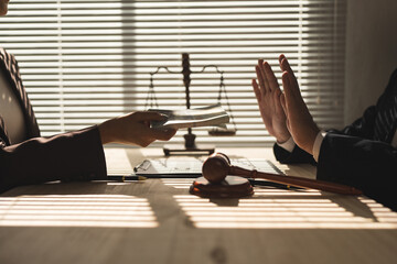 Lawyer, businessman or accountant is refusing money and resisting the partner's bribery agreement to settle a joint debt. Kickback, bribe money. Anti-illegal bribery concept at the desk in the office.