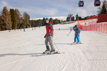 Children and adults, happy family in winter clothing at ski vacation, skiing, winter