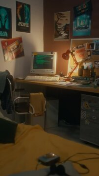 No people vertical shot of teenagers workspace with green code on black screen of old retro computer on desk in decorated room with colorful posters on walls