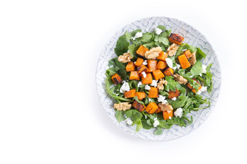 Pumpkin salad with arugula, walnuts and feta cheese isolated on white background. Top view. Copy space