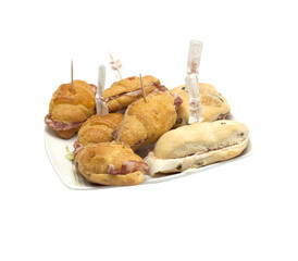 Assorted mini sandwiches on a plate with toothpicks for party snacks