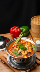 Tom Yum in a hot pot with traditional background