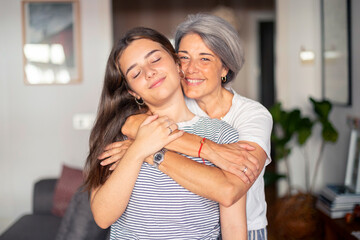 Mother hugging her daughter in a cozy living room