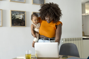 African mother multitasking with baby at home