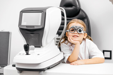 A child being examined with a slit lamp—a device with a microscope and focused light to assess...