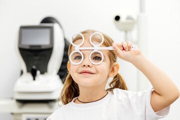 Diagnosis and improvement of vision in modern ophthalmology in young patients. The girl playfully...