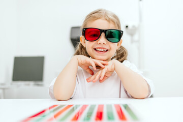 Orthoptic therapy. The concept of vision restoration and training. A cheerful smiling girl wearing...