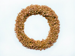 Obraz premium Brown sugar pebbles arranged in a circle or circular pattern to form like a ring, isolated on a white background, view from top.