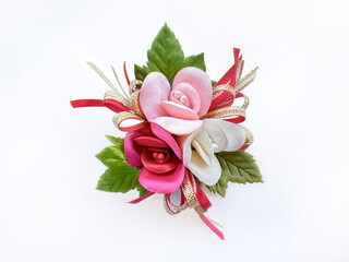 Flower corsage brooch arrangement in colors of pink, red, and white rose with green leaves and ribbons. Cheerful red flower corsage accessories or decoration for clothes. Isolated on white background. © TMR Studio
