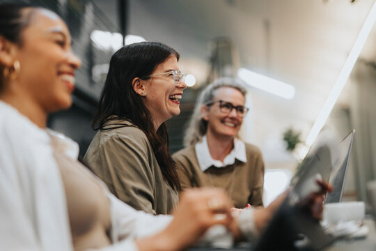 Happy businesswoman with female colleagues working at office