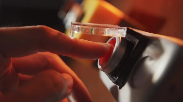 Pushing a red start button with cover