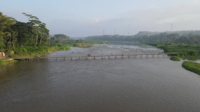 Aerial footage shows a wooden bridge spanning the Progo River, passable by motorbikes. As a link between the villages of Bantul and Kulonprogo.