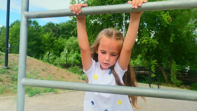 Sporty child girl doing morning workout on street sports ground. Fitness workout. a healthy family. street sports ground in a city park in casual clothes. Street workout