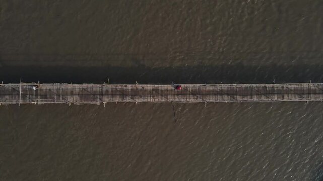 Aerial footage shows a wooden bridge spanning the Progo River, passable by motorbikes. As a link between the villages of Bantul and Kulonprogo.