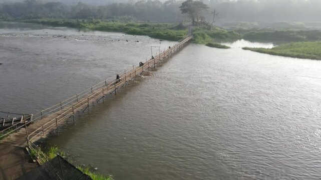Aerial footage shows a wooden bridge spanning the Progo River, passable by motorbikes. As a link between the villages of Bantul and Kulonprogo.