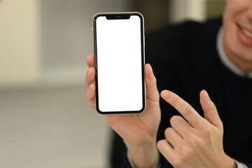 Close up image of man pointing finger at smartphone with blank screen