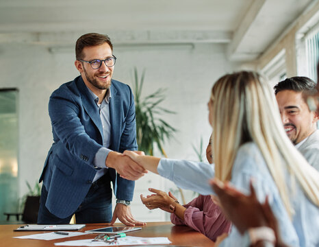 young business people meeting office handshake hand shake shaking hands teamwork  agreement black happy smiling success partnership introduction greeting businessman man introducing businesswoman 