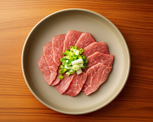 Fototapeta premium A plate of meat with green onions on top 