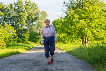 Fototapeta premium Old woman on a walk. Selective focus.