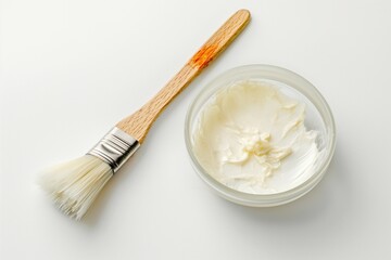 Bowl contains chemical peel and brush. Isolated on white background. Peeling procedure for skincare and facial care. Chemical exfoliation for healthy and rejuvenated skin.