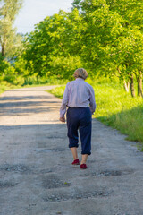 Old woman on a walk. Selective focus.
