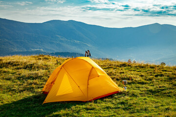Hiking in the mountains in summer with a tent. Beautiful sunset in the mountains.