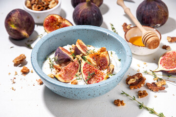 Creamy rich and tasty yogurt dessert with autumn figs, granola and nuts