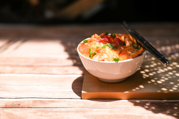 Udang asam manis or sweet and sour shrimp. one of chinese cuisine, shrimp is cooked with garlick, leek, chilli and a sweet and sour sauce added to the white bowl before serving.