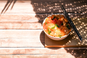 Udang asam manis or sweet and sour shrimp. one of chinese cuisine, shrimp is cooked with garlick, leek, chilli and a sweet and sour sauce added to the white bowl before serving.