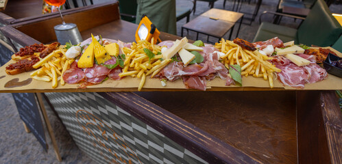 SYRACUSE, ITALY, JUNE 21, 2023 - A large amount of cold cuts, cheeses and chips  displayed outside a restaurant in Syracuse Ortigia, Sicily, Italy