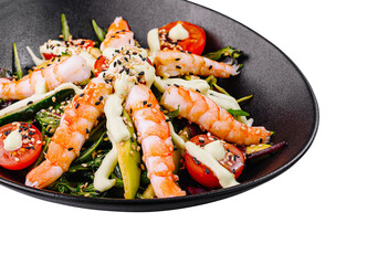 Fresh salad with shrimps, avocado and cherry tomatoes on black plate