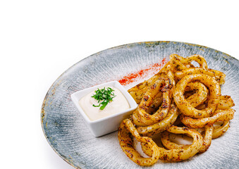 Fried squid rings served with white sauce on elegant restaurant plate