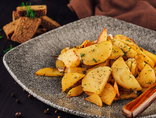 Delicious fried potatoes with dill served on plate