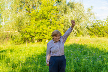 An old woman doing exercises in nature. Selective focus.