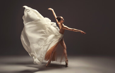 Ballerina. Young graceful woman ballet dancer, dressed in professional outfit, shoes and beige...