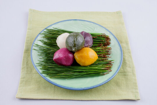 Various colored Songpyeon(half-moon-shaped rice cake) with pine needles on a dish, South Korea. It is Korean traditional food eaten during New Year's Day or Korean Thanks Giving Day