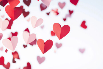 Obraz premium Colorful paper hearts cascading against a light background during a festive celebration