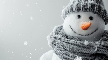 Obraz premium Cheerful snowman wearing a knitted hat and scarf under falling snowflakes in winter