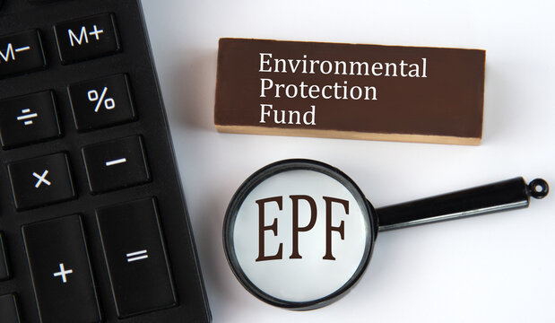 EPF - acronym on a brown wooden block with a calculator and magnifying glass in the background