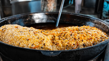 The concept of oriental cuisine. Assorted Uzbek food set, pilaf, samsa, lagman, manta, shurpa central asia food. Homemade Uzbek pilaf or plov from lamb served in cast iron cookware