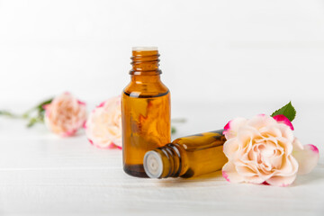 Rose essential oil on a textured background.Roses and a bottle of rose perfumed water.Aromatherapy treatment. Beauty concept. Spa procedure.Natural organic oil.Anti-stress,detox relax.Place for text