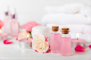 Rose essential oil on a textured background.Roses and a bottle of rose perfumed water.Aromatherapy treatment. Beauty concept. Spa procedure.Natural organic oil.Anti-stress,detox relax.Place for text