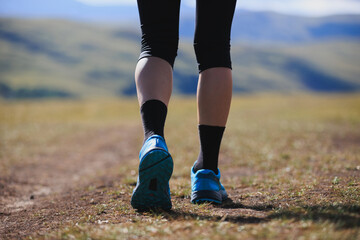 Fitness woman runner running at high altitude grassland mountain top road