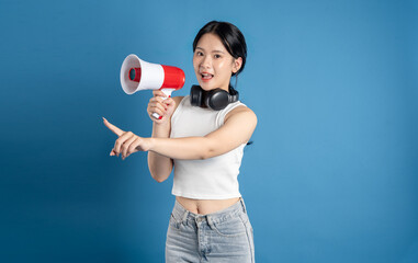 Portrait of beautiful Asian woman posing on blue background.