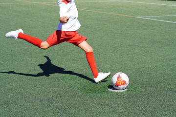 faceless image of preadolescent boy running for a penalty shot