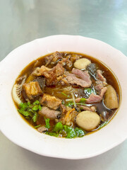 A delicious bowl of savory meat soup with herbs and vegetables, perfect for comfort food lovers and food enthusiasts.