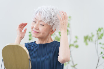 ヘアセットをするシニア女性