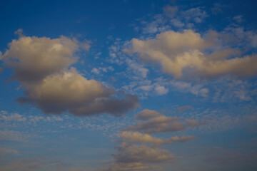 Sunlight yellow light of the setting sun on white clouds, evening skies, celestial landscape with sunset clouds