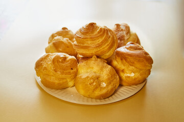Close-up of appetizing profiteroles on a white dish for culinary content.