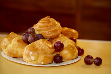 Profiteroles and grapes on a plate, captured up-close, highlighting the harmony of flavors.